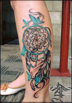 a woman's leg with a tattoo on it and a blue dream catcher in the center