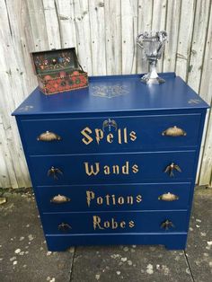 a blue dresser with gold lettering on it