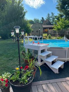 an above ground pool with steps leading up to it and potted plants in the foreground