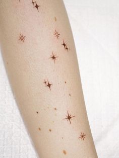 a close up of a person's arm with small stars on the back of it