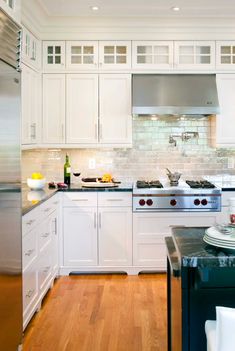 a kitchen with white cabinets and stainless steel appliances