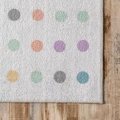 a white rug with multicolored polka dots on the front and back of it