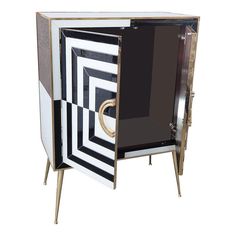 an art deco cabinet with black and white designs on the doors, gold handles and legs