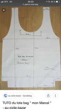 the back of a white tank top that is cut out and ready to be sewn