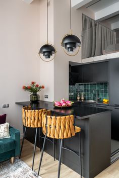 a kitchen with black counter tops and yellow chairs