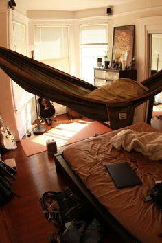 a hammock hanging over a bed in a bedroom