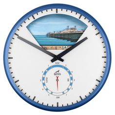 a blue and white clock with a painting of a pier on the water behind it