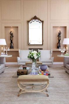 a living room filled with furniture and a mirror on the wall above it's coffee table