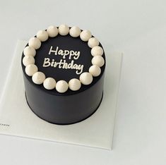 a black birthday cake with white frosting on top