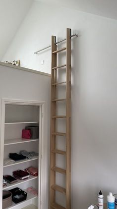 a ladder leaning up against the wall in a room with shoes and other items on it