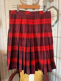 This is a beautiful, thick wool skirt - The In 'n Outer by Sportrite Junior, Canada and Great Britain - in dark navy blue and red plaid. It has the added bonus of being reversible to a skirt that is more red than blue! The skirt fastens with buttons and a zipper. The measurements, taken with the skirt lying flat, are: waist, 15 inches; hips, 25 inches; length, 22 1/2 inches; bottom edge, 50+ inches. In very good condition. Red Pleated Winter Skirt, Scottish Style Plaid Lined Skirt, Scottish Style Fitted Pleated Skirt For Fall, Fall Scottish Pleated Skirt, Scottish Plaid Skirt For Winter, Scottish Plaid Pleated Bottoms, Winter Scottish Plaid Skirt, Scottish Style Pleated Skirt For Fall, Scottish Style Fitted Plaid Pleated Skirt