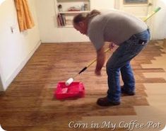 a woman is cleaning the floor with a mop and duster in her house