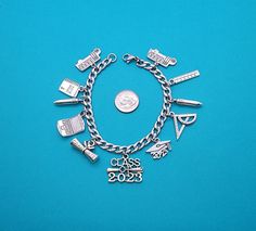 "This Graduation Charm Bracelet is a Great Gift for a Grad.... Please measure wrist to see the bracelet chain size needed (add 1/2\" for comfort). Want a custom size? Message us.We have 2025 charms, message us if interested. Bracelet is 304 stainless steel with a lobster clasp, it is a link curb chain in a silver tone. It is 20.5cm (8 1/8\") long. Cut down sizes are listed. Curb chain size: 9mm x 6mm ( 3/8\" x 1/4\"). Charms are made of zinc alloy (lead and nickel free).  Charms measurement are from 25 mm x 20mm to 22mm x 5mm. PLEASE NOTE: From time to time I may need to substitute one of the charms for another of equal or greater value... all keeping with the theme of the collection. Each bracelet arrives in its own white box, perfect for gift giving. Visit the rest of our shop at Charmed Silver Charm Bracelet With Adjustable Chain For Party, Metal Charm Bracelet With Jubilee Detail For Gifts, Personalized Adjustable Bracelets For Graduation, Pandora Graduation Charm, Silver Tarnish-resistant Metal Charm Bracelet, School Teacher Gifts, Grad Gifts, Stainless Steel Bracelet, Personalized Jewelry