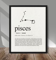 the pisces zodiac sign in black and white framed on a wooden floor next to a lamp