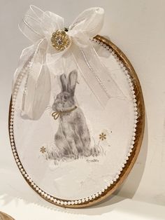 a glass plate with an image of a rabbit on it's side and a ribbon tied around the edge