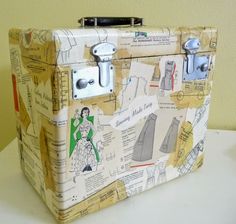 an old suitcase is covered with paper cutouts and magnets on the inside, sitting on a table