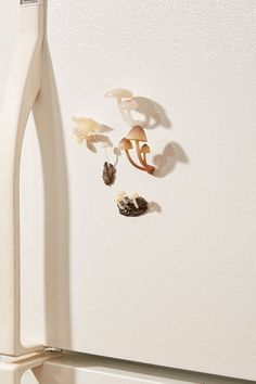 a white refrigerator freezer sitting next to a wall with magnets on the door