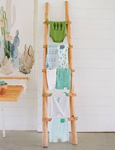 a wooden ladder with towels hanging from it's sides in front of a wall