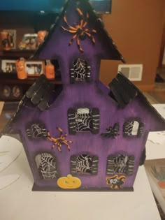 a purple house with spider webs and bats on it