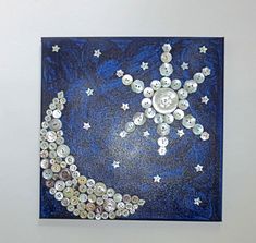 a painting with buttons and stars in the shape of a moon on a blue background