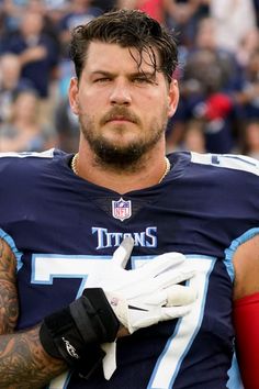 a close up of a person wearing a uniform and holding a football in his hands