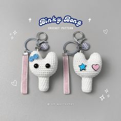 two crocheted keychains are shaped like a cat with a bow on its head