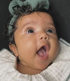 a close up of a baby with a surprised look on her face