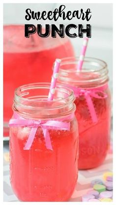 two mason jars filled with watermelon punch and pink straws on the side