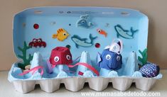 an egg carton filled with different types of sea animals on top of a table