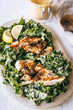 a plate with chicken and greens next to a cup of tea