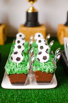 there are cupcakes with soccer balls in them on the plate and green grass