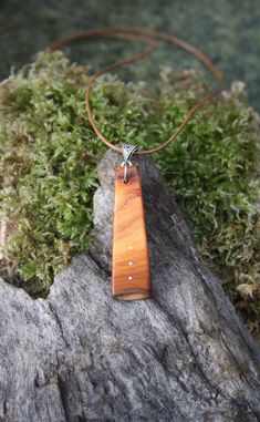 "A rare find, this beautiful and unique Irish yew wood necklace has been made for you, or a loved one, in my studio on the West of Ireland. This minimalist pendant features a piece of Yew wood, recycled from musical instruments constructed by a local luthier. As a musician myself, I take enormous satisfaction in creating a necklace whose inherent wood has previously featured in a beautiful hand-made harp or guitar. Considered one of the Sacred trees in the Celtic world, the Yew has long been ass Gift Wooden Bead Necklaces In Natural Wood, Natural Wood Necklaces With Wooden Beads For Gift, Artisan Natural Wood Necklace As A Gift, Artisan Necklace In Natural Wood As A Gift, Artisan Natural Wood Necklaces For Gift, Artisan Necklaces In Natural Wood As Gift, Wooden Pendant Necklace For Gift, Artisan Natural Wood Pendant Necklace, Spiritual Natural Wood Necklaces As Gift