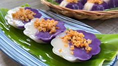 purple and white desserts with crumbs on them sitting on a green plate