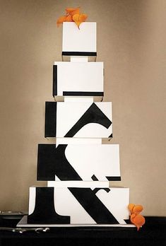 a black and white cake sitting on top of a table next to an orange ribbon