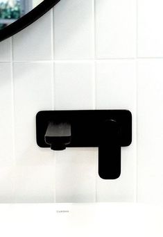 a black and white photo of a wall mounted toilet paper dispenser