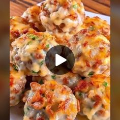 a white plate topped with cheesy meatballs covered in cheese and green onions