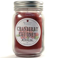 a jar filled with cranberry chutney sitting on top of a table