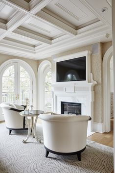 a living room with white furniture and a fireplace