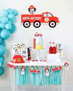 a birthday party with balloons, cake and decorations on a table in the shape of a firetruck