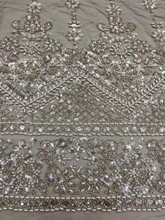 an embroidered fabric with silver sequins on it