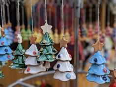 small ceramic christmas trees hanging from strings