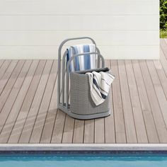 a towel rack next to a swimming pool with towels in it on the decking