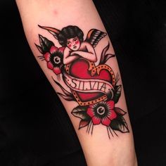 a woman with an arrow and heart tattoo on her arm that says alive, surrounded by flowers