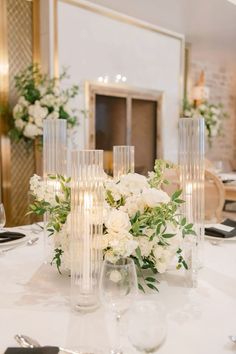 the table is set with white flowers and candles