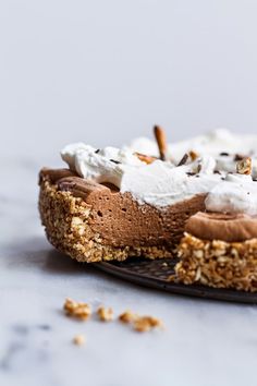 there is a chocolate pie with whipped cream and nuts on the top, ready to be eaten