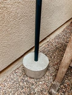 a baseball bat sitting on the ground next to a cement base in front of a building