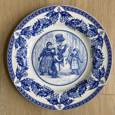 a blue and white plate with an image of two children in the woods on it