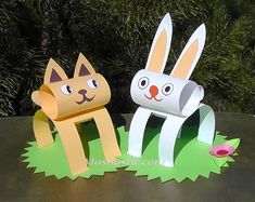 two paper rabbits sitting next to each other