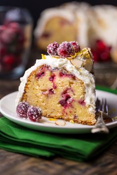 a slice of cake with white frosting and raspberries on top is sitting on a plate