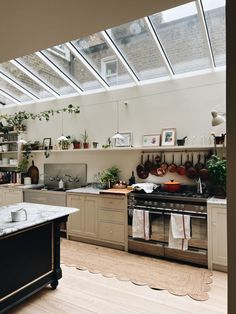 a kitchen filled with lots of counter top space next to a stove top oven under a skylight